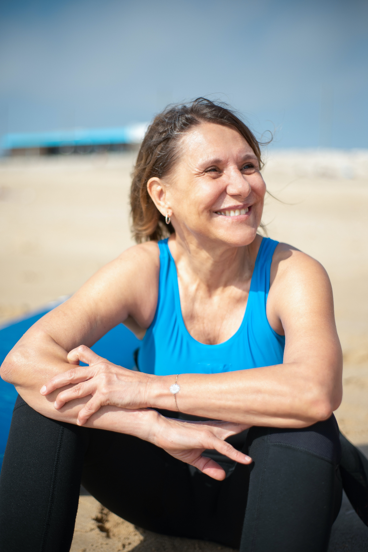 Image of an older woman in athletic wear sitting on a sandy beach smiling. Begin assessing your cognitive strengths with the help of adult neuropsychological testing in Saint Petersburg, FL.