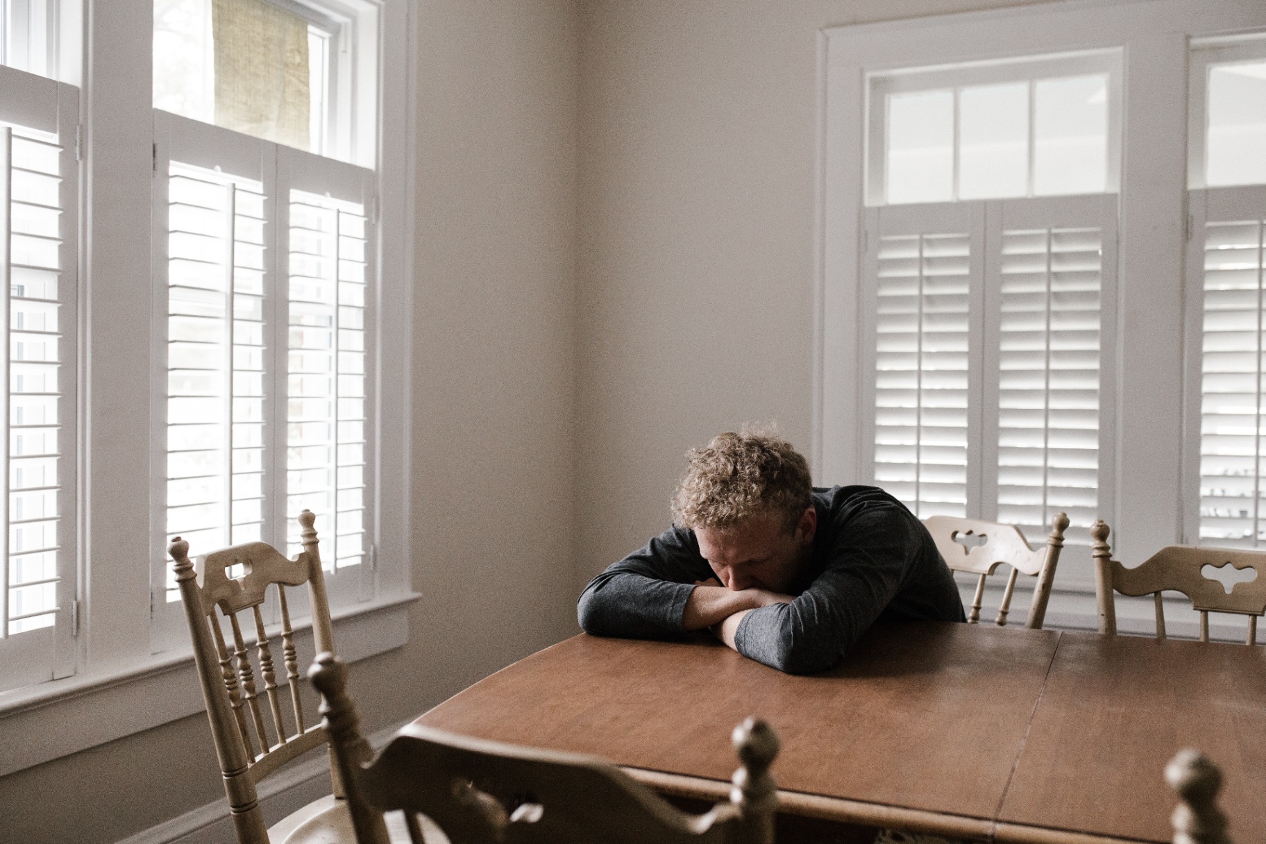 Image of an upset man laying his head on his arms at a table. Is your anxiety keeping you from living your life? Learn how anxiety therapy in Saint Petersburg, FL can help you begin working to overcome your symptoms in healthy ways.