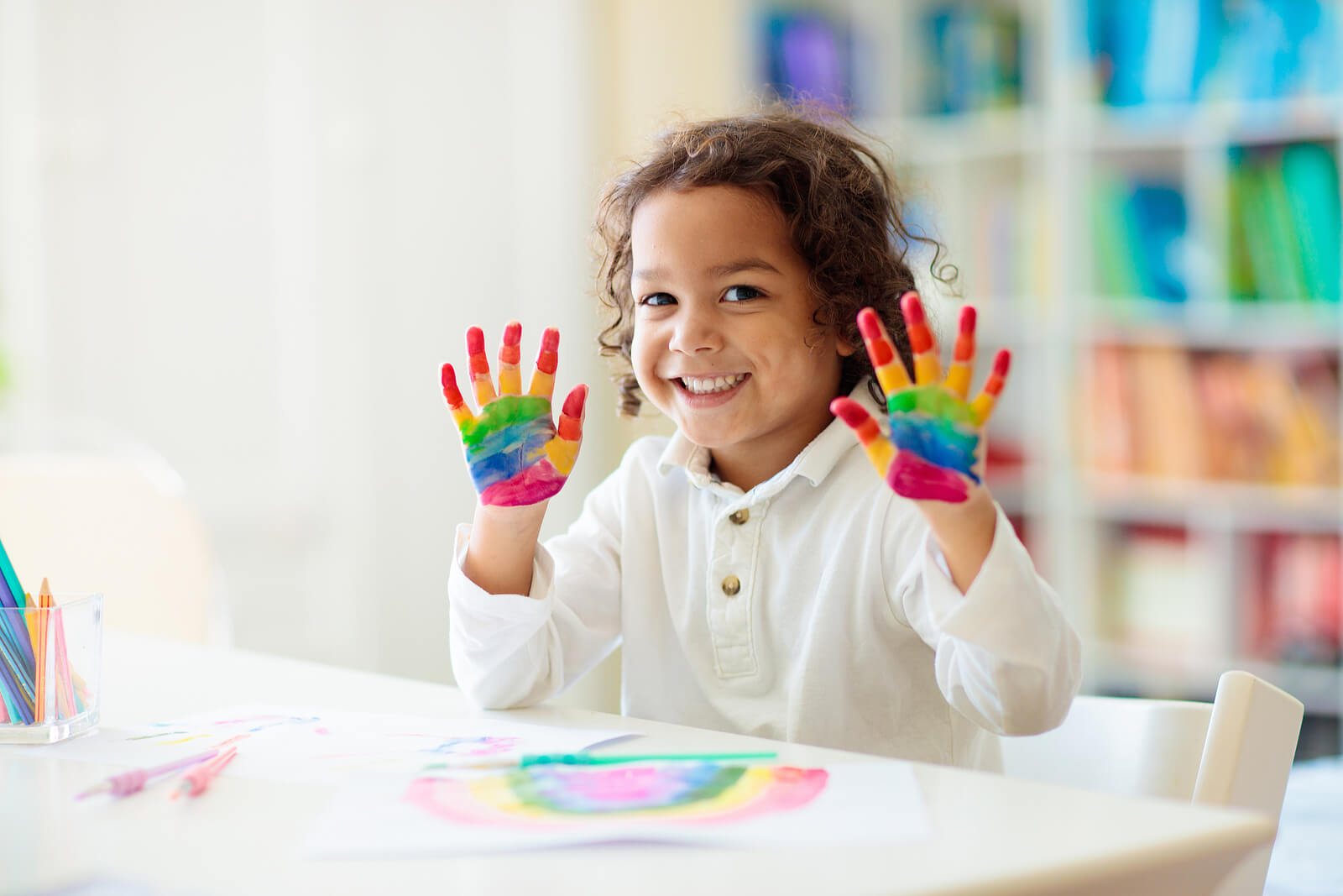 Image of a young child holding up their hands that are painted like the rainbow. If your child struggles with their behavior, find support with child neuropsych testing in Saint Petersburg, FL. A skilled neuropsychologist can help provide you and your child with support.
