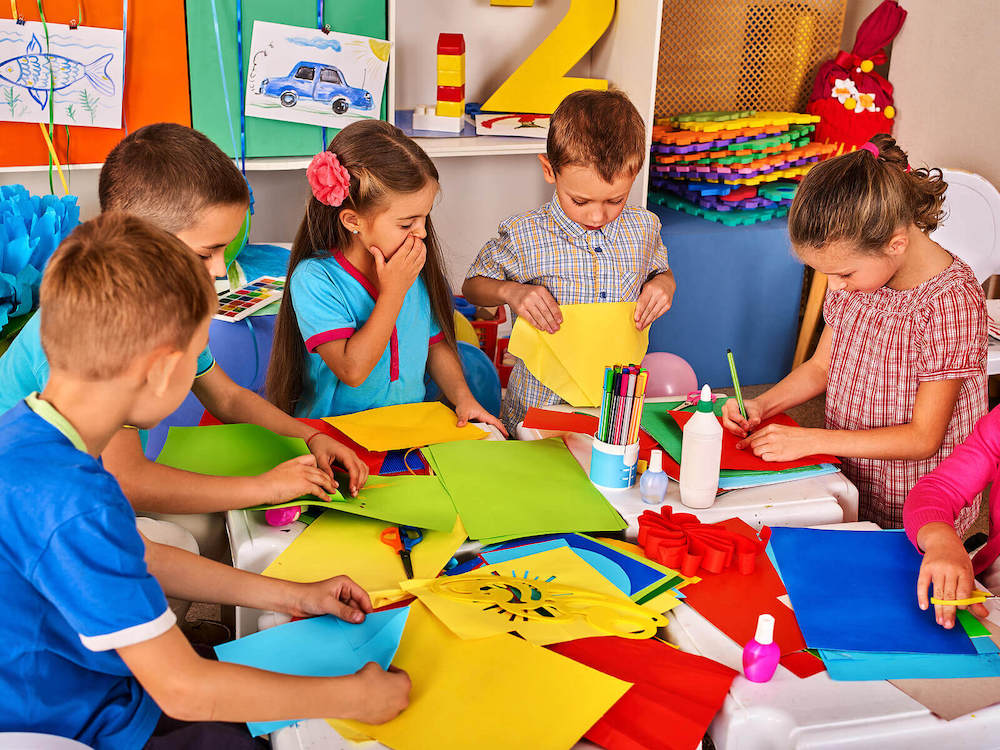 Photo of a group of small children drawing and cutting colorful paper at school. Start supporting your child and their learning disabilities with the help of child neuropsych testing in Saint Petersburg, FL.