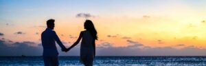 Couple holding hands on the beach at sunset. Couples therapy in Saint Petersburg, FL can help your relationship thrive today. Reach out to learn how a marriage therapist can support you.