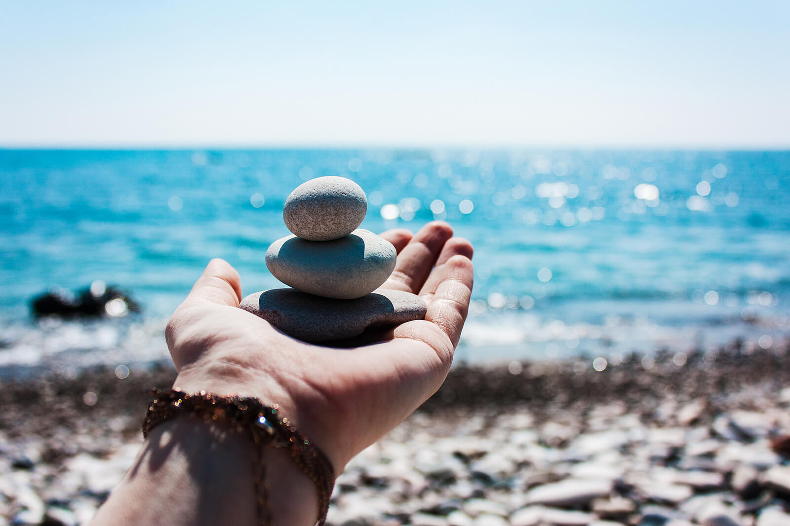 Image of someone holding balancing rocks toward the ocean. Find effective support in coping with your epilepsy and seizures with adult neuropsychological evaluations in Saint Petersburg, FL.