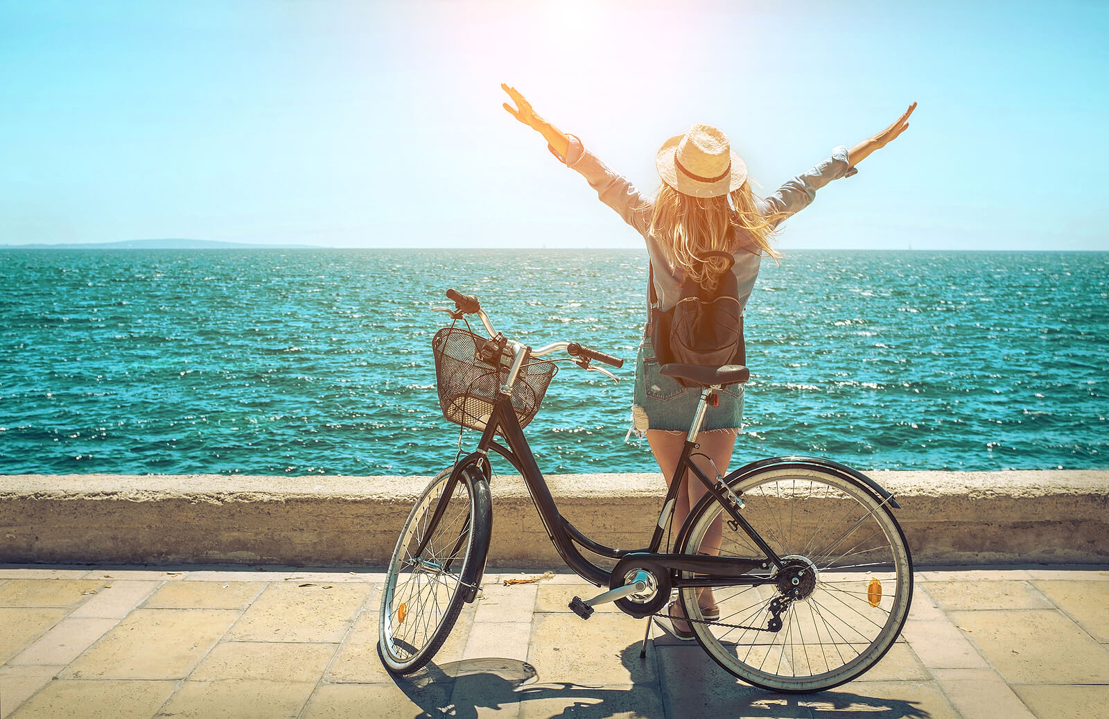 Image of a woman standing near a bike in front of the ocean holding her arms up on a sunny day. Do you suffer from panic attacks? Learn how anxiety therapy in Saint Petersburg, FL can help you find your triggers and understand how to cope.
