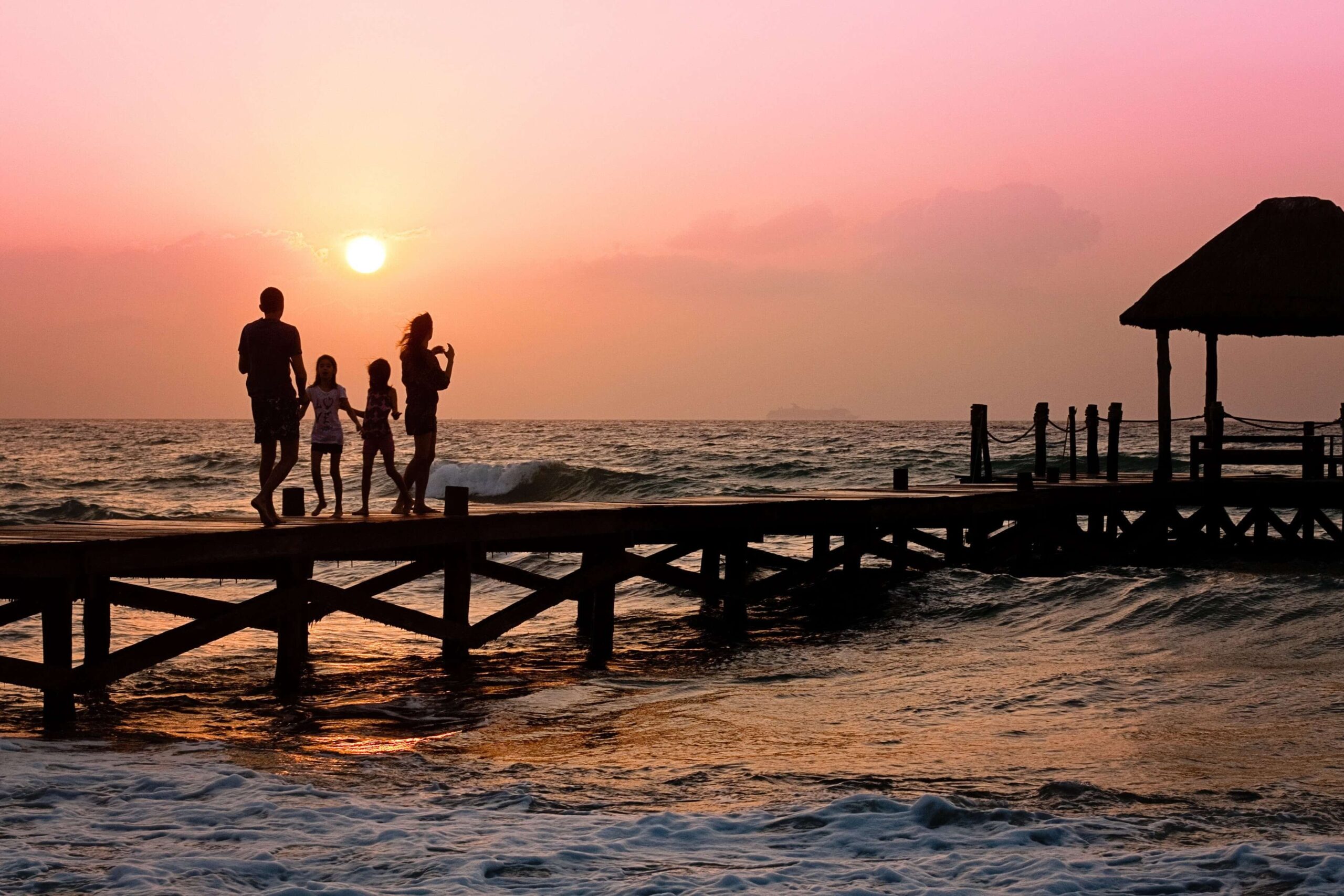 Family walking on the pier at sunset. Looking for a family therapist in Saint Petersburg, FL to help you reconnect or overcome challenges? Call today.