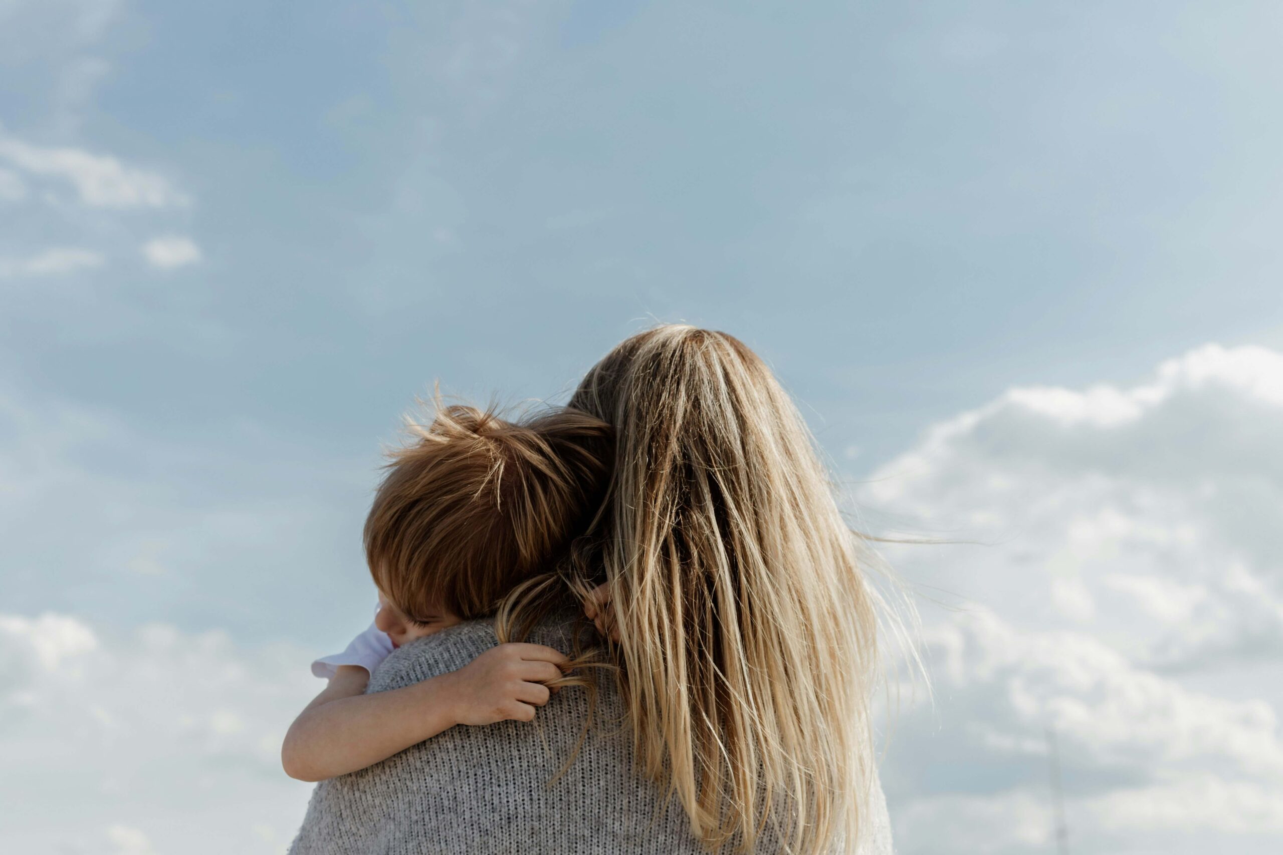 Image of a woman holding her son on a sunny day. Learn to support your child and help them cope with their anxiety with anxiety therapy in Saint Petersburg, FL.