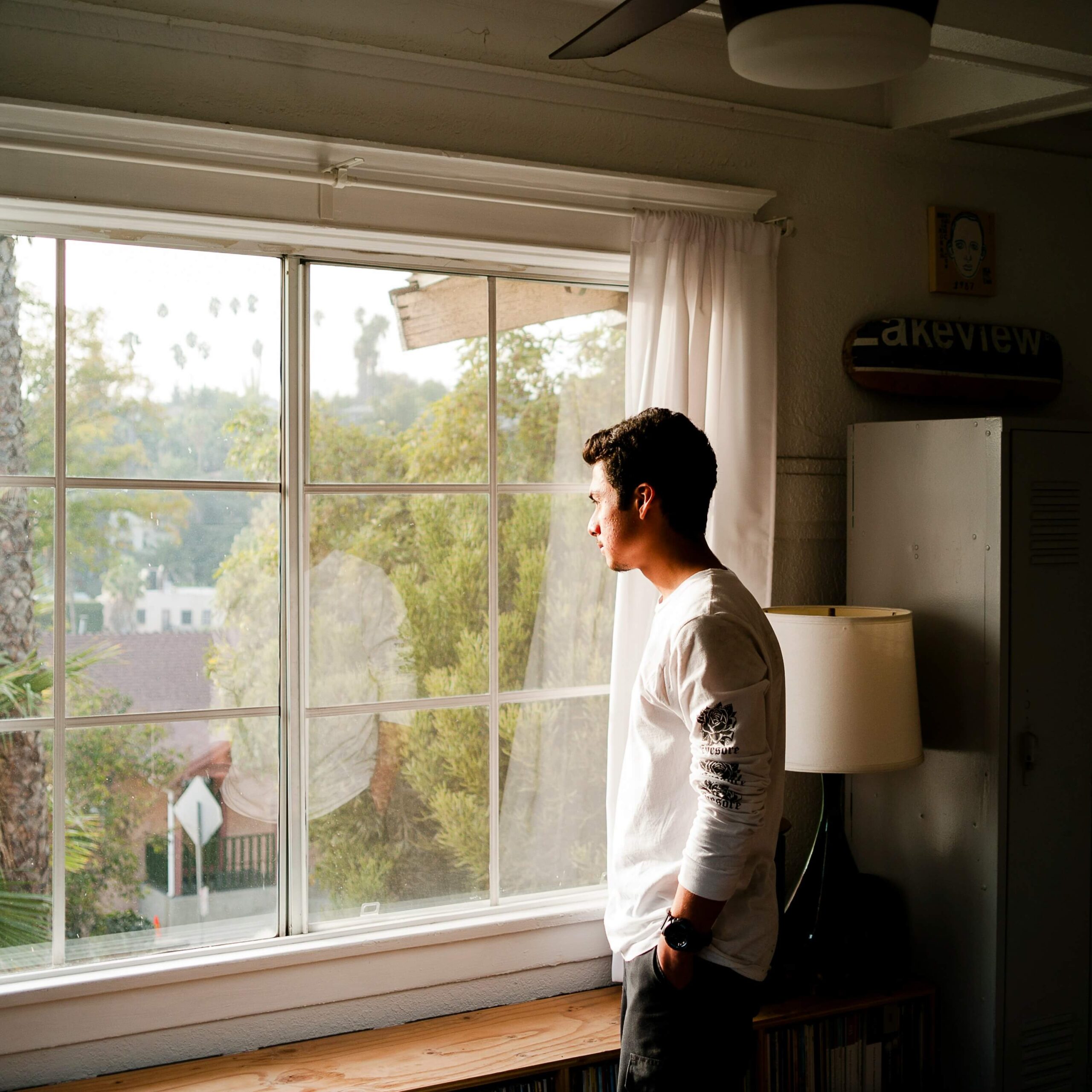 Image of a man looking out a window thoughtfully with his hands in his pocket. If you struggle with memory loss due to trauma, learn how trauma therapy in Saint Petersburg, FL can help.