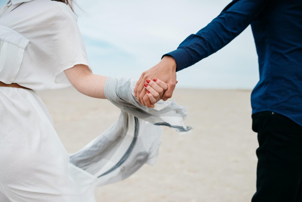Married couple walking on beach holding hands in harmony. Looking to overcome challenges in your marriage or relationship? Couples therapy can support you through the struggles in Saint Petersburg, FL.