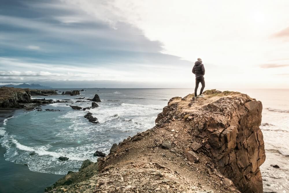 Image of a man standing on top of a cliff overlooking the ocean. Overcome your past trauma with the help of a skilled trauma therapist in Saint Petersburg, FL.